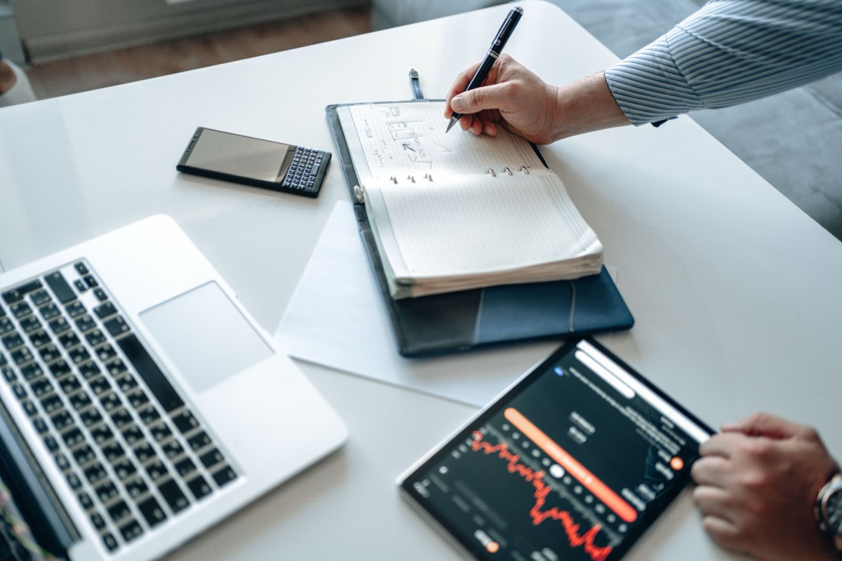 Personne utilisant un ordinateur avec un téléphone et une tablette